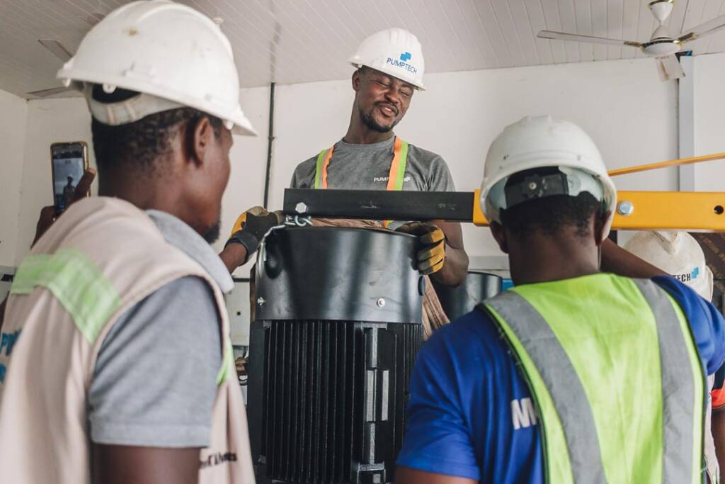 Technicians installing solar water pump in a pump house